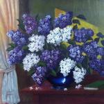 Lilacs in a blue vase on the table by the window