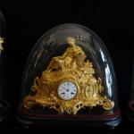 The bronze clock with candlesticks under glass bel The bronze clock with candlesticks under glass bel