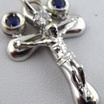 White gold cross with diamond and paired blue sapp White gold cross with diamond and paired blue sapp