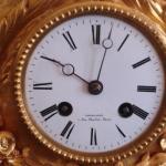 The bronze clock with candlesticks under glass bel The bronze clock with candlesticks under glass bel