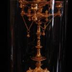 The bronze clock with candlesticks under glass bel