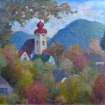 Autumn in small town with a church tower and hills