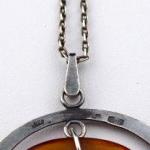 Silver necklace, circle, and oval amber