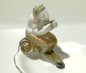 Satyr sitting on the edge of a bowl