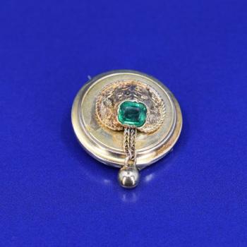 Gold brooch with emerald