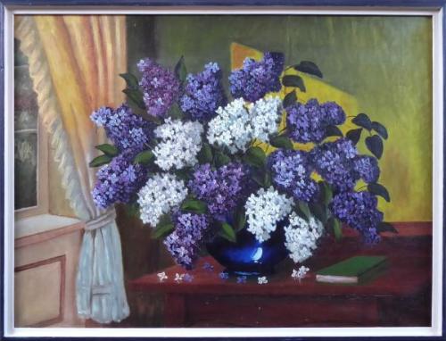 Lilacs in a blue vase on the table by the window